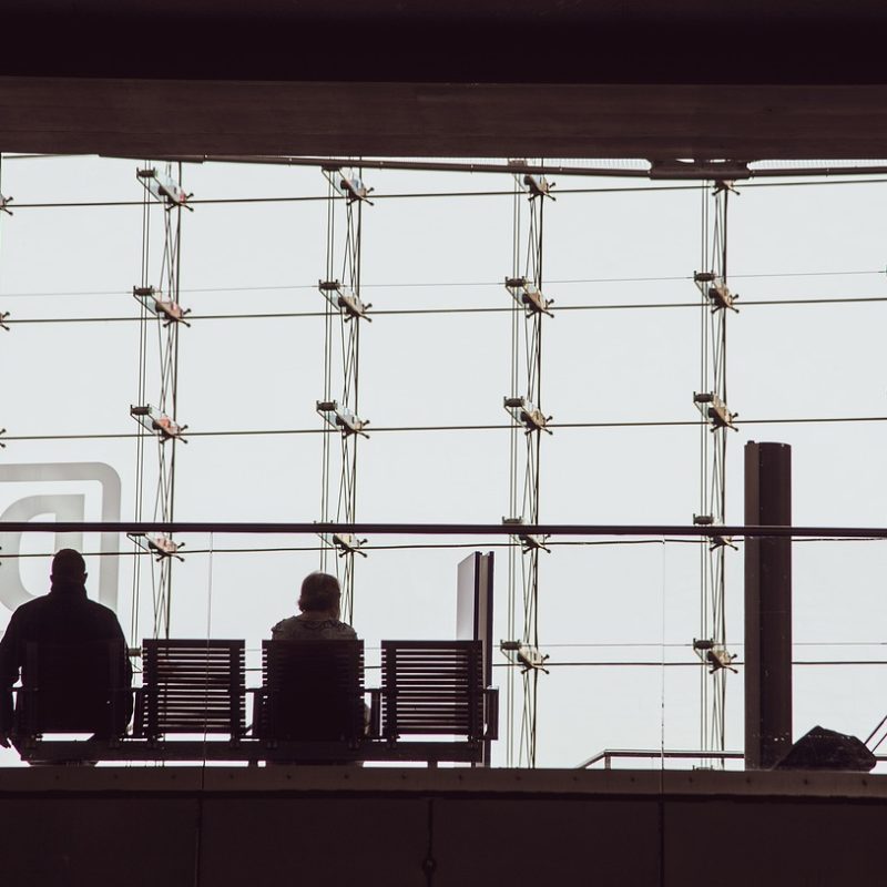 Silhouettes of people in a modern building with a large glass wall