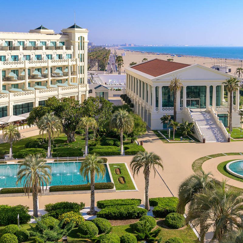 iew of the entrance to Hotel Balneario Las Arenas in Valencia, showcasing its grand architecture and lush surroundings