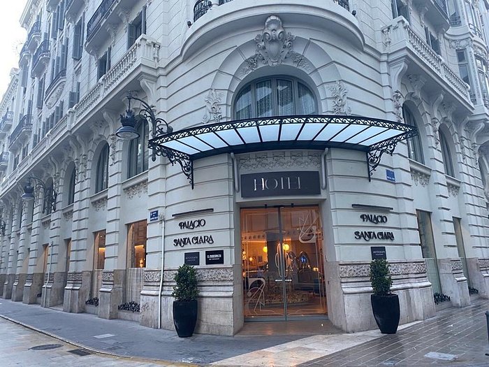 Puerta de entrada del Hotel Palacio Santa Clara en Valencia, con una arquitectura elegante y detalles históricos