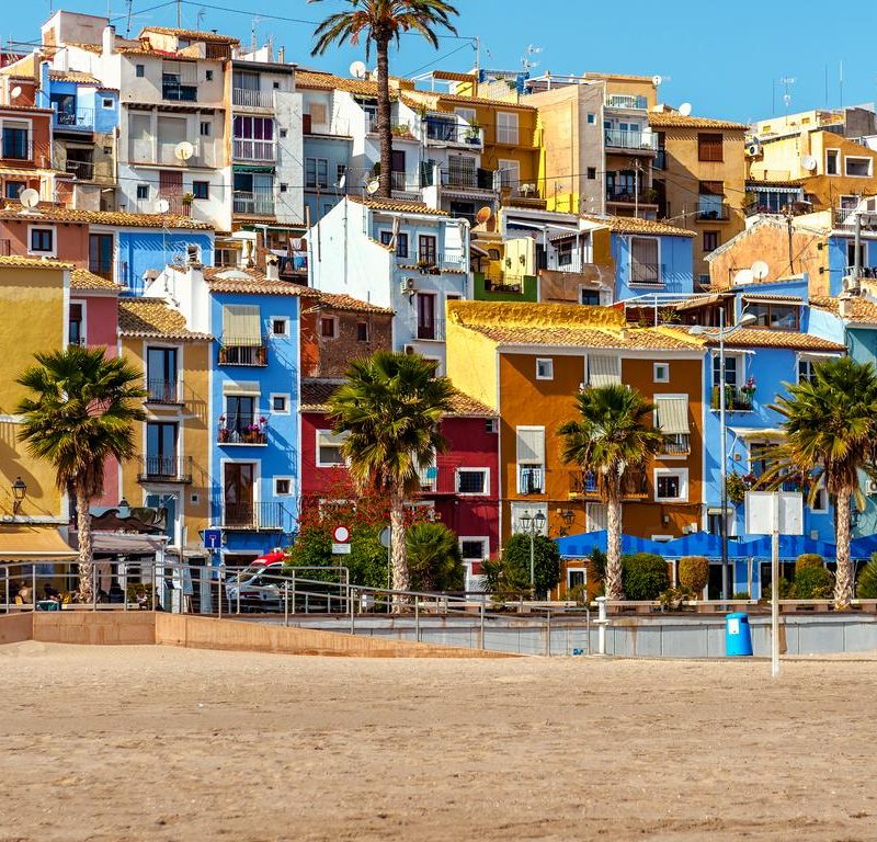 View of the vibrant seafront promenade in Villajoyosa, featuring colorful houses lined up along the coastline