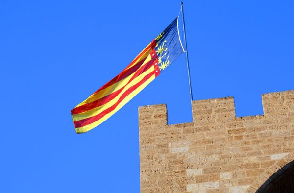 La Senyera de la Comunidad Valenciana ondeando en lo alto de una torre, simbolizando la festividad local