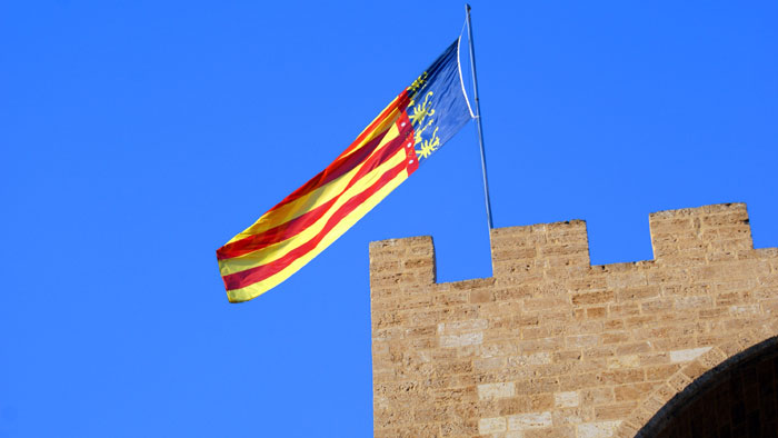 La Senyera de la Comunidad Valenciana ondeando en lo alto de una torre, simbolizando la festividad local