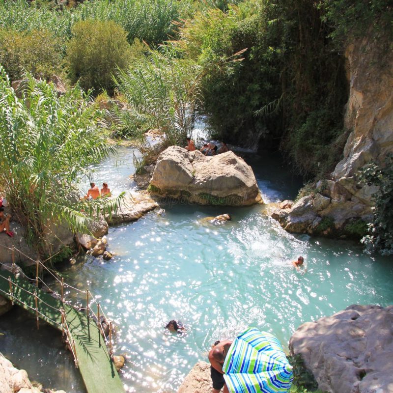 Vue des Fuentes del Algar, avec des cascades et des piscines naturelles entourées de végétation luxuriante