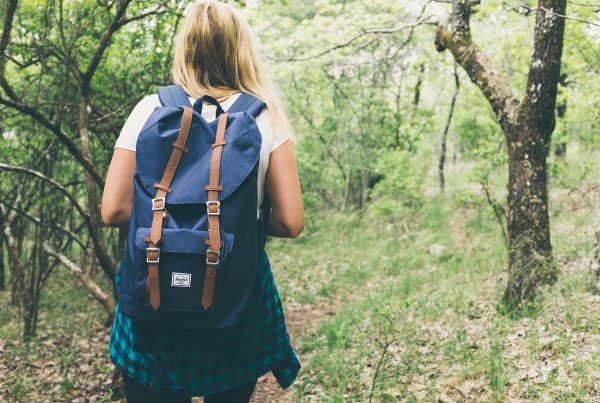 Fille de dos avec un sac à dos, marchant sur un sentier de randonnée à Valencia, entourée de nature