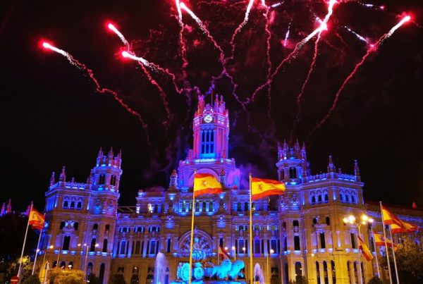 Espectáculo de fuegos artificiales iluminando el Palacio de Cibeles en Madrid durante el Día de la Hispanidad