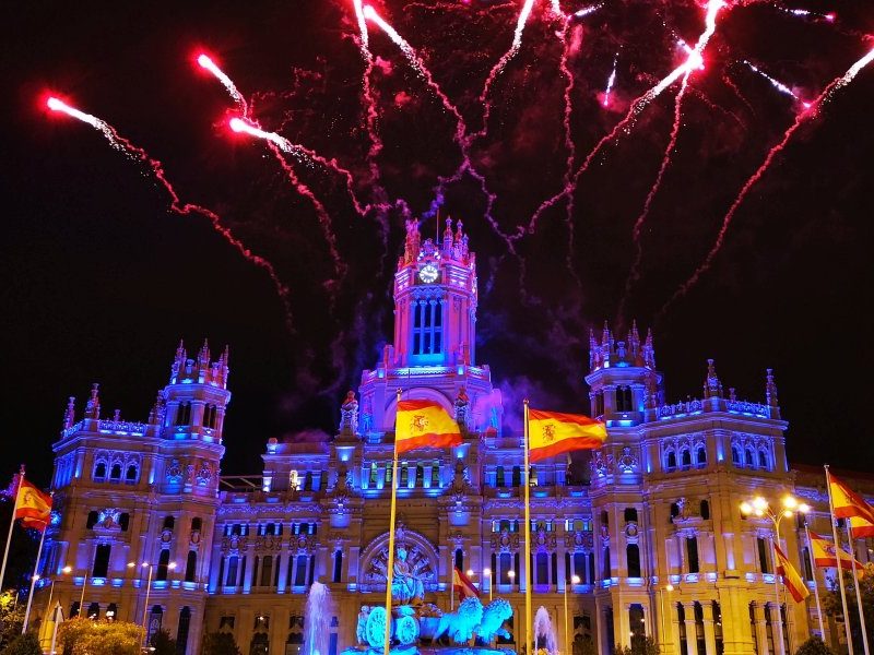 Espectáculo de fuegos artificiales iluminando el Palacio de Cibeles en Madrid durante el Día de la Hispanidad