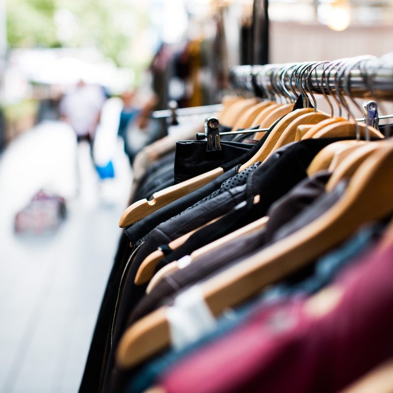 A clothes rack displaying various garments for sale, showcasing a selection of fashion items on the shopping route in Las Palmas