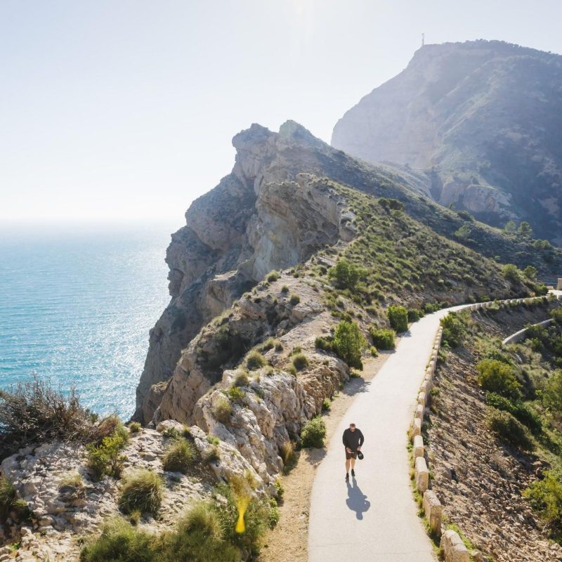 Hiking trail in Benidorm with a road and the sea in the background.