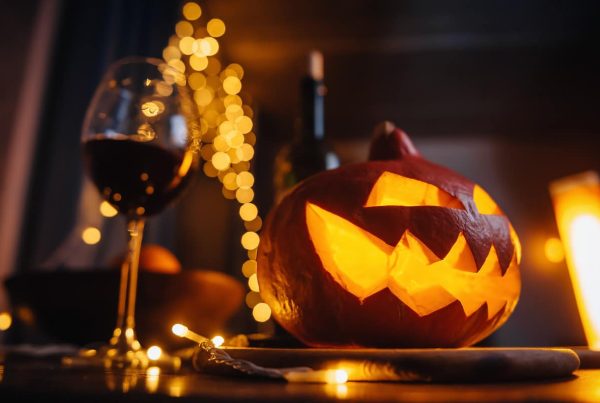 Calabaza decorativa de Halloween con una copa de vino al lado