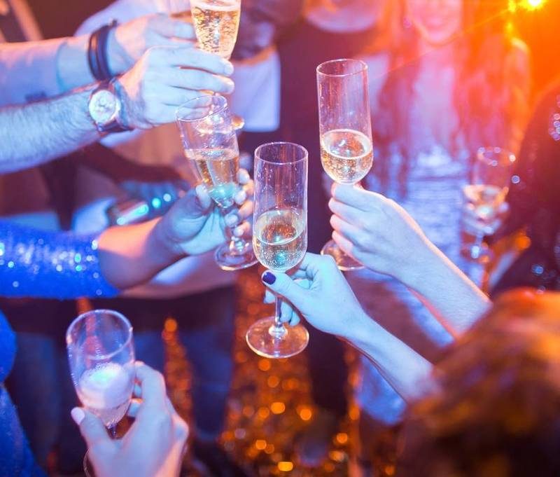 Un groupe de personnes trinquant, célébrant la Saint-Sylvestre 2024 à Séville avec des verres levés