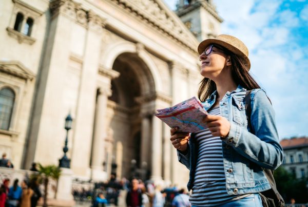 A girl standing in front of a monument holding a map