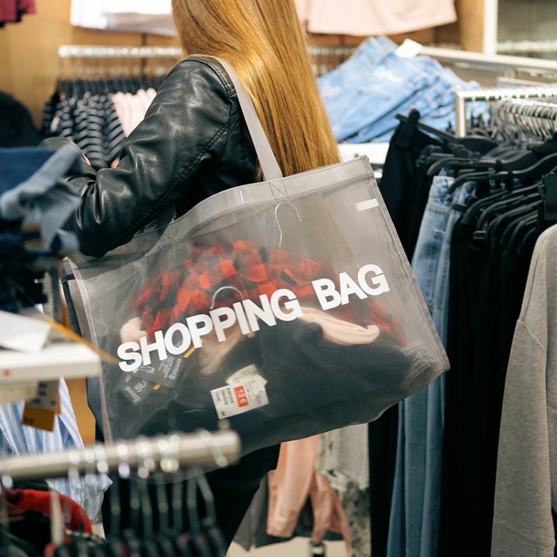 Une femme avec un sac de shopping à l’intérieur d’un magasin de vêtements à Malaga