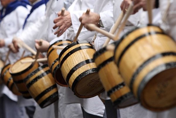 Personas tocando un tambor durante la celebración de la Tamborrada de San Sebastián