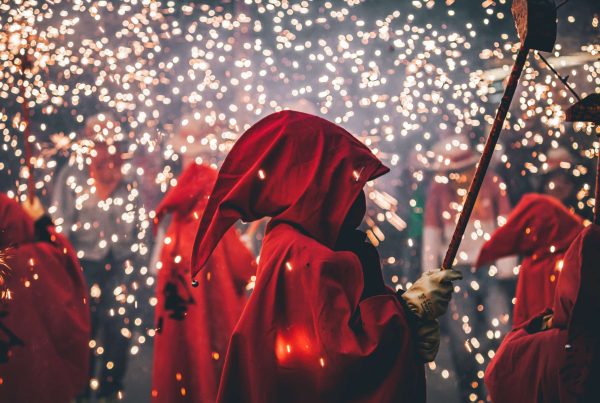 Des personnes profitant du spectacle des correfocs, avec des étincelles et des costumes traditionnels, lors des Fêtes de Santa Eulalia à Barcelone