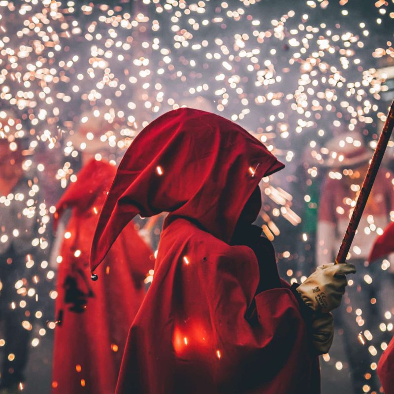 Des personnes profitant du spectacle des correfocs, avec des étincelles et des costumes traditionnels, lors des Fêtes de Santa Eulalia à Barcelone