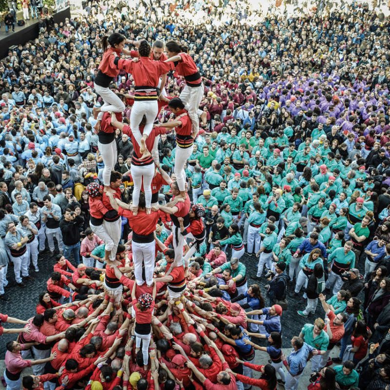 People building human towers (castells) during the Fiestas de Santa Eulalia in Barcelona, showcasing tradition and teamwork