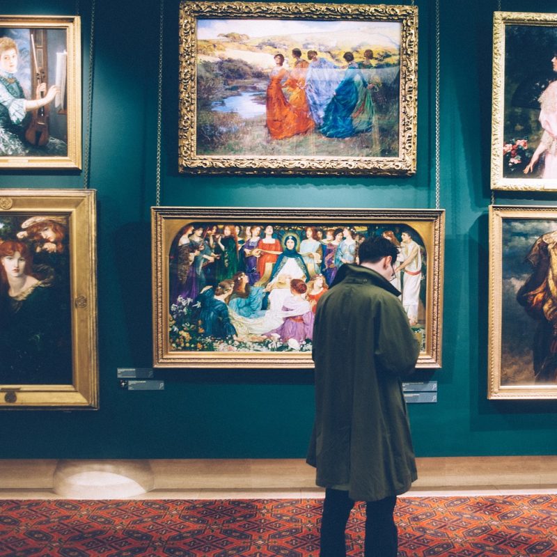 A man admiring famous paintings at the Museo del Prado in Madrid, exploring its world-renowned collection