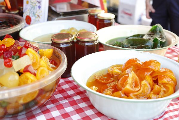 Table full of jams and candied fruits at the Feria de San Ponç in Barcelona, showcasing traditional sweet delicacies