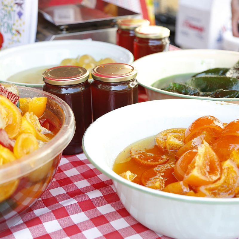 Table full of jams and candied fruits at the Feria de San Ponç in Barcelona, showcasing traditional sweet delicacies