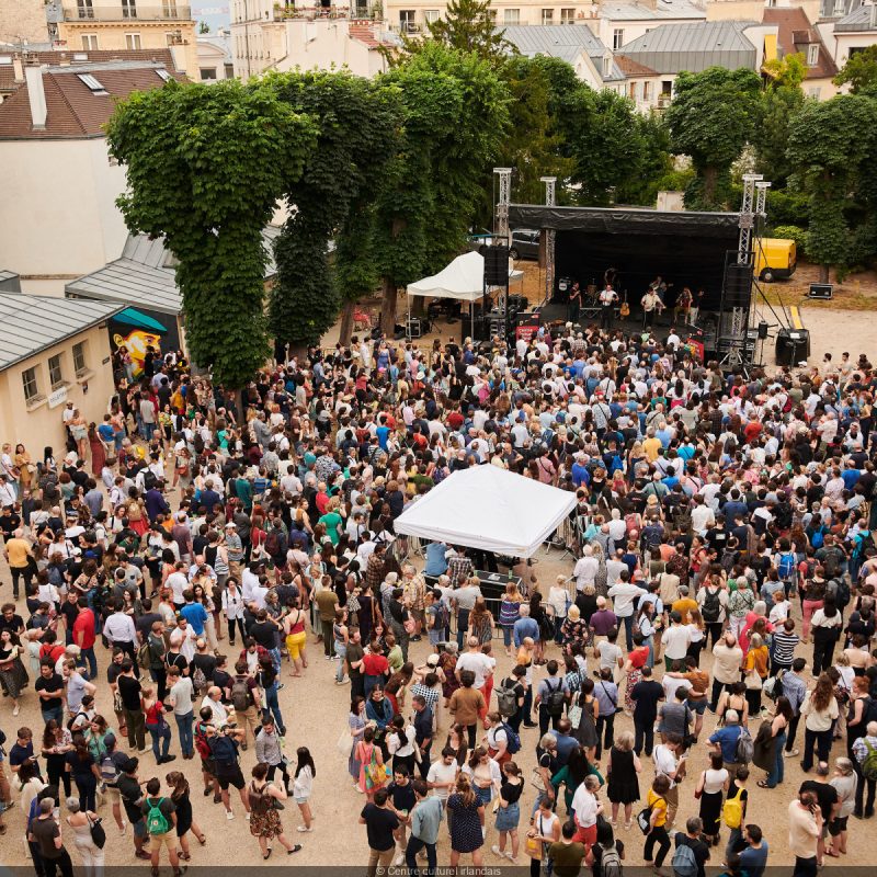 Multitud disfrutando de un concierto al aire libre en un jardín durante la Fiesta de la Música en París
