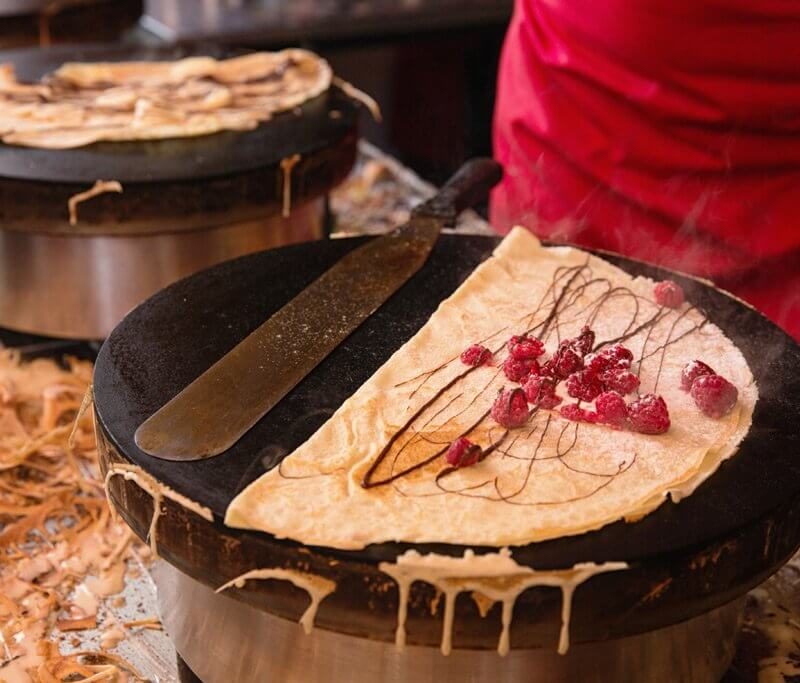 A freshly made crêpe cooking in a skillet in a Parisian kitchen