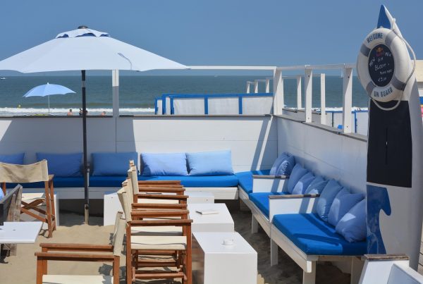 Beachside chiringuito in Benidorm with wooden tables, sun umbrellas, and the sea in the background on a sunny summer day