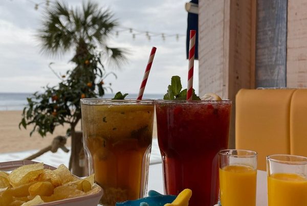 erres de mojito frais servis sur une table en bois dans un chiringuito de plage à Benidorm, avec vue sur la mer en arrière-plan