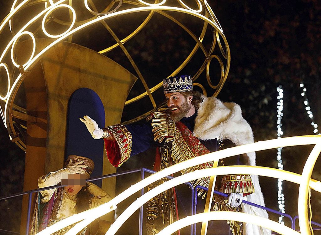 Rey Mago saludando desde una carroza durante la Cabalgata de Reyes en Madrid ante familias y niños