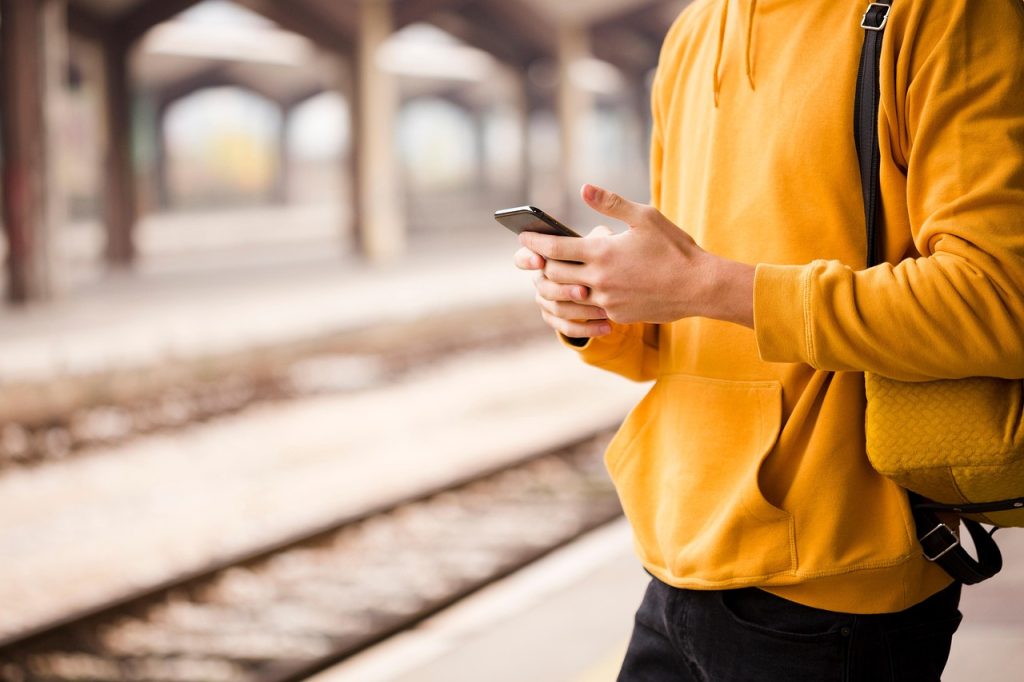 Turista consultando el móvil en la estación de Santa Justa antes de iniciar rutas a pie por Sevilla